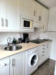 a kitchen with a sink and a washing machine at La Arena in Miengo