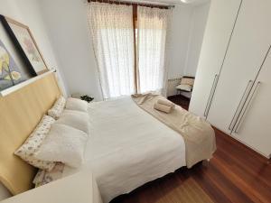 a bedroom with a white bed and a window at La Arena in Miengo