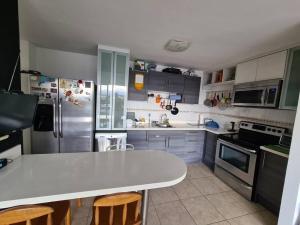 a kitchen with a white counter top and a refrigerator at Apartment with city view in Oasis de San José in San José