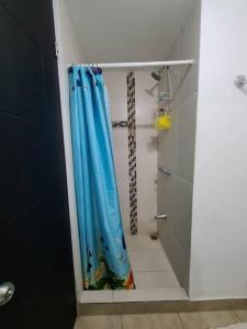 La salle de bains est pourvue d'une douche avec un rideau de douche bleu. dans l'établissement Apartment with city view in Oasis de San José, à San José