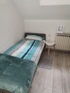 1 dormitorio con cama y mesa pequeña en Apartman Mia en Slavonski Brod