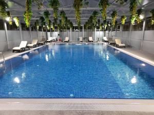 a large swimming pool with chairs in a hotel at Dostyk Hotel Bautino in Fort-Shevchenko