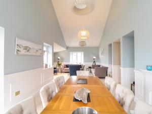 a dining room with a wooden table and chairs at Wild Acres in Helston
