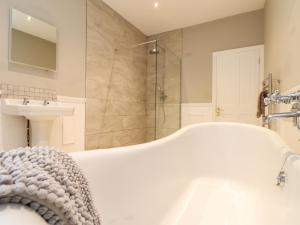 a bathroom with a tub and a shower and a sink at Wild Acres in Helston +33 photos