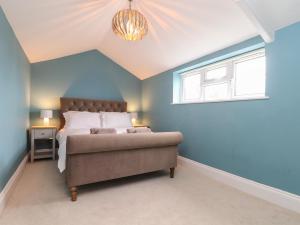 a bedroom with a bed in a room with blue walls at Wild Acres in Helston
