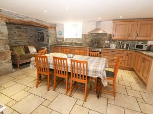 a kitchen and dining room with a table and chairs at Tyn Llwyn in Talsarnau