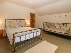 1 dormitorio con cama y banco. en Tyn Llwyn, en Talsarnau