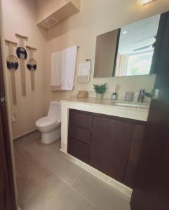 een badkamer met een toilet, een wastafel en een spiegel bij 2 Bed Bath for 5 Casa Azul in Tulum