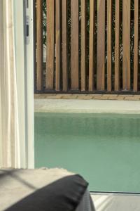 una piscina d'acqua accanto a una recinzione di legno di 2 Bed Bath for 5 Casa Azul a Tulum