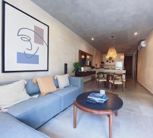 a living room with a blue couch and a table at Fully Equipped 2BR2Bath wPrivate Pool in La Veleta in Tulum