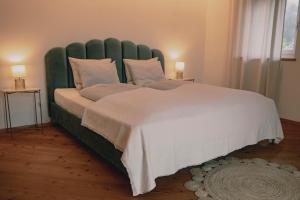 a large bed with a green headboard in a bedroom at 164 apt. in Val di Vizze