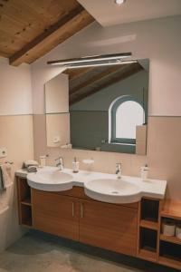 a bathroom with two sinks and a large mirror at 164 apt. in Val di Vizze