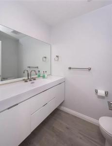 a white bathroom with a sink and a mirror at Private room in beautiful modern Calabasas townhouse in Calabasas