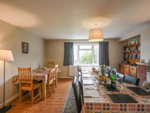 eine Küche und ein Esszimmer mit einem langen Tisch in der Unterkunft Garth Ucha in Llanyblodwel