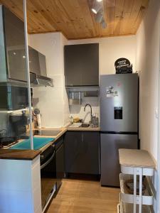 a small kitchen with a refrigerator and a sink at Le Hohwald centre appartement 2 pièces # 102 in Le Hohwald
