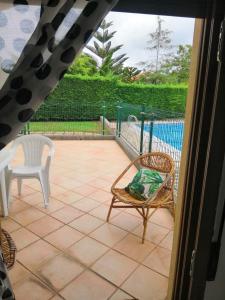 un patio con 2 sillas y una piscina en La Arena, en Miengo