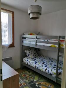 1 dormitorio con 2 literas y alfombra en Beau T3 place parking, vue dégagée proche centre, en Luchon