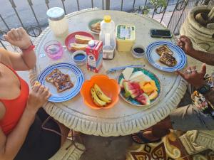 eine Gruppe von Menschen, die an einem Tisch mit Frühstückslebensmitteln sitzen in der Unterkunft Casa del Agua in Granada