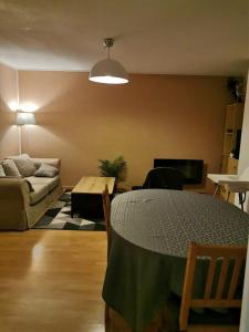 uma sala de estar com uma mesa e um sofá em Beau T3 place parking, vue dégagée proche centre em Luchon