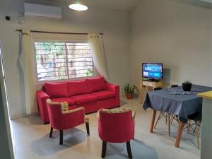 La Cascada 2 في بوساداس: غرفة معيشة مع أريكة حمراء وطاولة