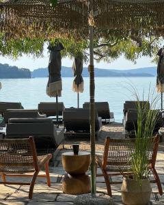 un gruppo di sedie e ombrelloni in spiaggia di Eva beach hotel a Nydri