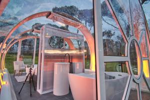 vistas a un baño con cámara y espejo en Tubbo Experience by Camping Osuna, en Madrid