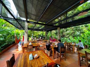 eine Gruppe von Personen, die in einem Restaurant an Tischen sitzen in der Unterkunft Origen Hostel in El Zaino