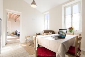 a bedroom with a bed with a laptop on it at La Virginie - Suite Ile'Ô in La Couarde-sur-Mer