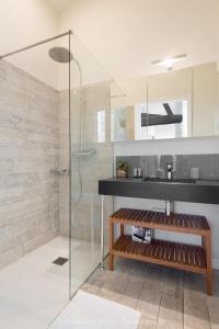 a bathroom with a glass shower and a bench at La Virginie - Suite Ile'Ô in La Couarde-sur-Mer