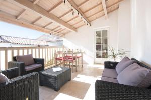 un patio con muebles de mimbre, mesa y sillas en La Virginie - Suite Ile'Ô, en La Couarde-sur-Mer