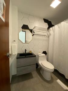 a bathroom with a toilet and a sink and a mirror at Hotel Nest in San Juan