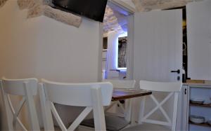 a dining room with white chairs and a table at TRULLI MATRICE in Alberobello