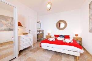 a bedroom with a red bed with two stuffed animals on it at Les Oules Vertes YourHostHelper classé 3 étoiles in Théoule-sur-Mer