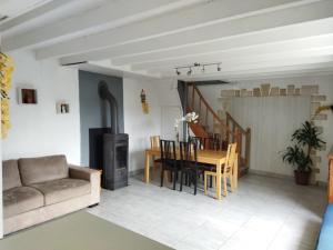 a living room with a couch and a dining room table at Charmante maison in Saint-Michel-le-Cloucq