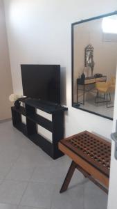 - un salon avec une télévision et un miroir dans l'établissement Sun Suite Sorrento center, à Sorrente