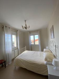 1 dormitorio blanco con 1 cama y 2 ventanas en Casa Rural Ana en Zorita