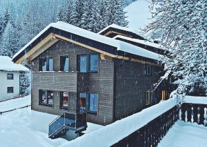 a wooden house with snow on the roof at Haus Pitzi in Sankt Anton am Arlberg