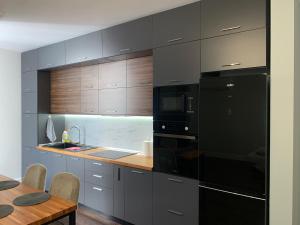 a kitchen with black appliances and a wooden table at Royal apartament in Durrës