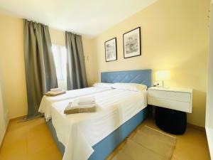 1 dormitorio con 1 cama grande y cabecero azul en El Paraiso Residence Club Mallorca, en Sa Ràpita