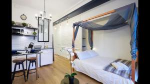een slaapkamer met een hemelbed en een keuken bij Le Gatsby 3 étoiles in Aix-les-Bains