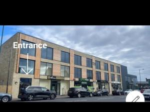 a large building with cars parked in front of it at MNA Superior Apartments in Bradford