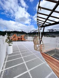 a patio with a swing on a roof with mountains at Ushuaia Extremo Sur in Ushuaia