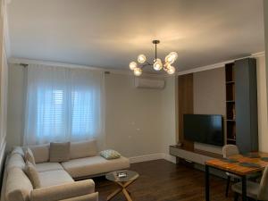 uma sala de estar com um sofá e uma televisão de ecrã plano em Royal apartament em Durrës