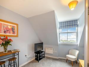 a living room with a desk and a tv and a window at Bay View - Uk38589 in Inverkeithing