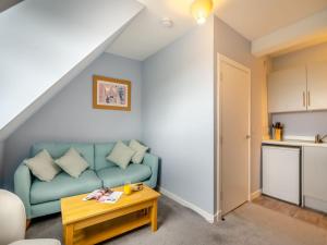 sala de estar con sofá azul y mesa en Bay View - Uk38589, en Inverkeithing