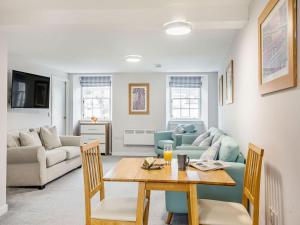 a living room with a table and a couch at Inverkeithing View - Uk38588 in Inverkeithing