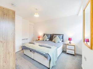 1 dormitorio con 1 cama y mesita de noche con 2 lámparas en Inverkeithing View - Uk38588, en Inverkeithing