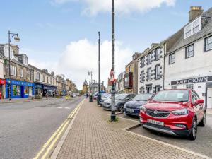 un coche rojo estacionado al lado de una calle en Inverkeithing View - Uk38588, en Inverkeithing