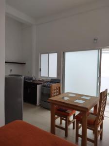 een keuken met een tafel en stoelen en een keuken met een koelkast bij Gal - Habitaciones Confortables in Cuernavaca