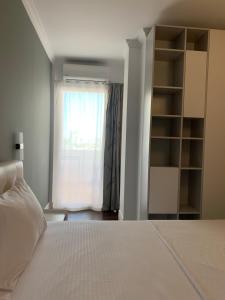 um quarto com uma cama branca e uma janela em Royal apartament em Durrës